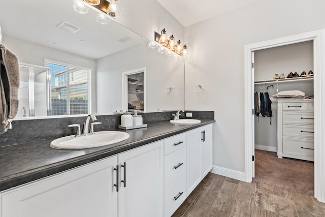 3430 Hermosa Ave, Clovis, CA 93619 - full bath with double vanity, a walk in closet, a stall shower, and wood finished floors