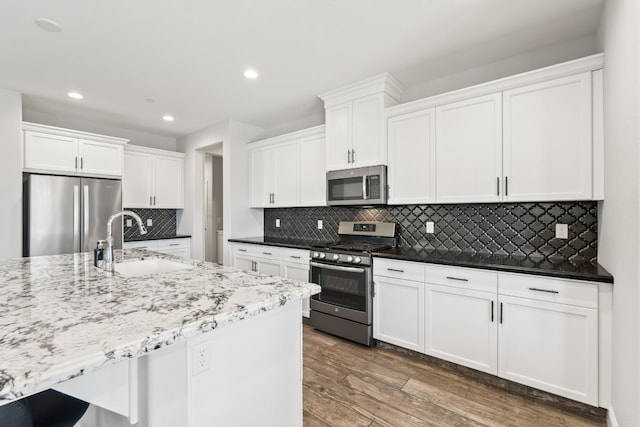 3430 Hermosa Ave, Clovis, CA 93619 - kitchen featuring stainless steel appliances, recessed lighting, wood finished floors, white cabinets, and tasteful backsplash