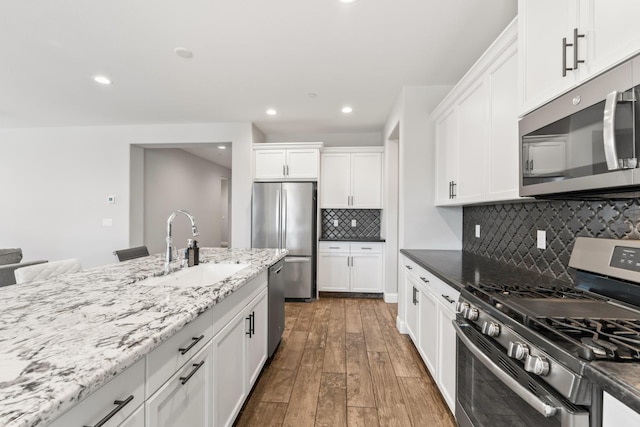 3430 Hermosa Ave, Clovis, CA 93619 - kitchen featuring stainless steel appliances, hardwood / wood-style floors, decorative backsplash, recessed lighting, and white cabinetry