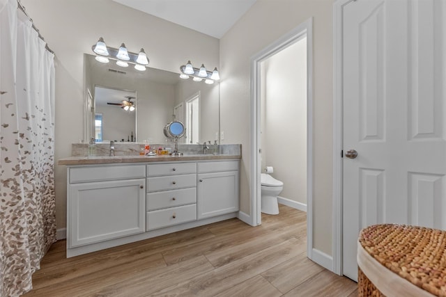 7387 E Robinson Ave, Fresno, CA 93737 - bathroom featuring double vanity, wood finished floors, and a ceiling fan