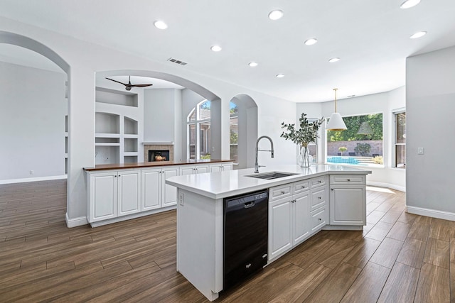 1552 N Gateway Ave, Clovis, CA 93619 - kitchen with black dishwasher, a center island with sink, recessed lighting, a lit fireplace, and dark wood-style flooring