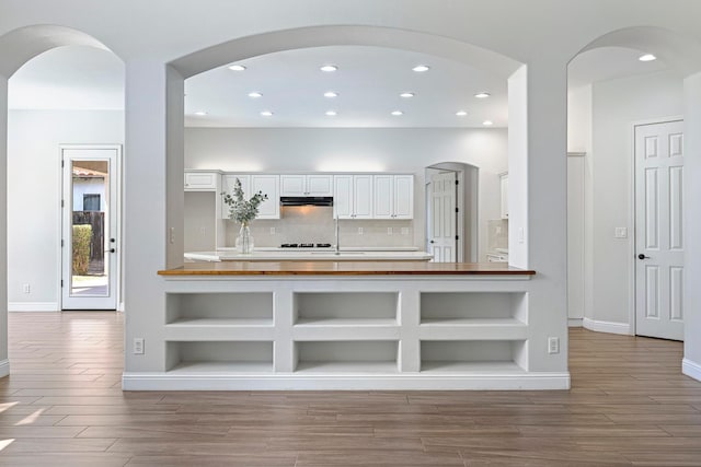 1552 N Gateway Ave, Clovis, CA 93619 - kitchen featuring under cabinet range hood, wood finished floors, white cabinetry, recessed lighting, and white cooktop
