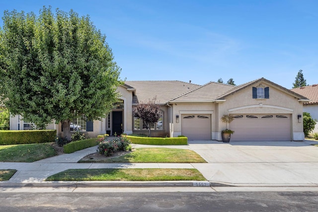 1552 N Gateway Ave, Clovis, CA 93619 - view of front facade featuring a garage, concrete driveway, a tiled roof, and stucco siding