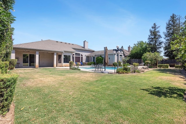 1552 N Gateway Ave, Clovis, CA 93619 - rear view of house with an outdoor pool, a chimney, stucco siding, and a patio area
