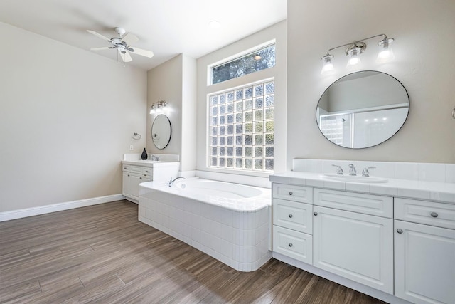 1552 N Gateway Ave, Clovis, CA 93619 - bathroom featuring two vanities, a garden tub, wood finished floors, and ceiling fan