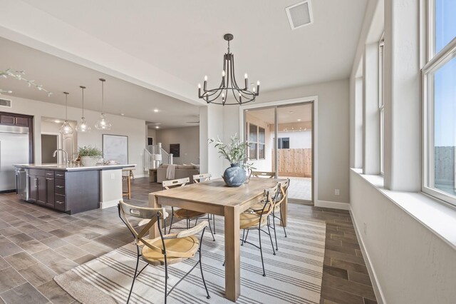 974 Talus Way S, Madera, CA 93636 - dining space featuring a chandelier, wood finish floors, and plenty of natural light