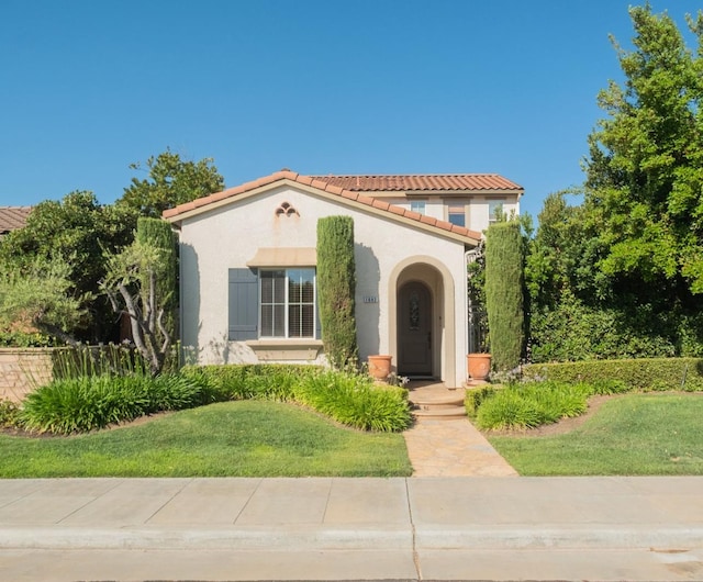 1682 N Dutch Ave, Clovis, CA 93619 - mediterranean / spanish home with a tile roof, stucco siding, and a front lawn