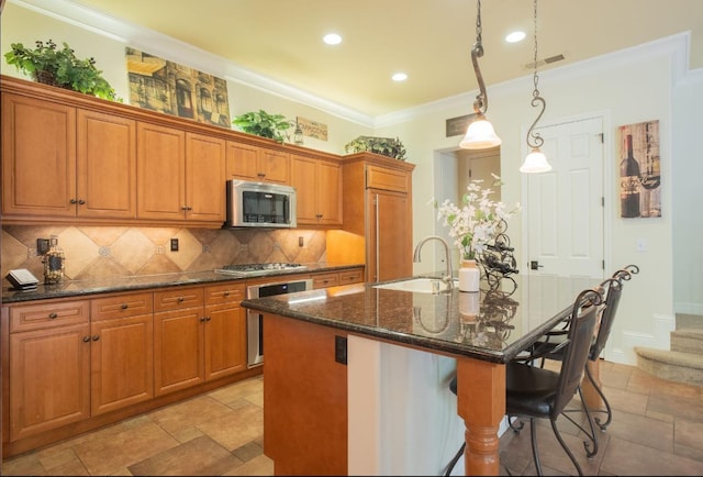 1682 N Dutch Ave, Clovis, CA 93619 - kitchen with stainless steel appliances, stone tile floors, brown cabinets, decorative backsplash, and a breakfast bar area