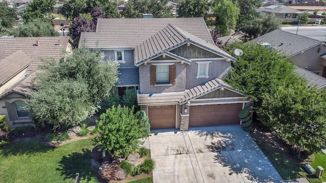 1090 Clara Ave, Fowler, CA 93625 - view of front of property featuring driveway, a tile roof, a garage, stucco siding, and a residential view