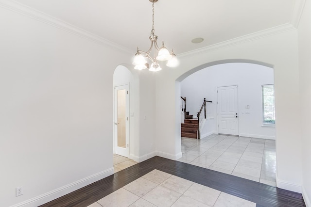 1090 Clara Ave, Fowler, CA 93625 - entryway featuring arched walkways, crown molding, a chandelier, stairs, and tile patterned flooring