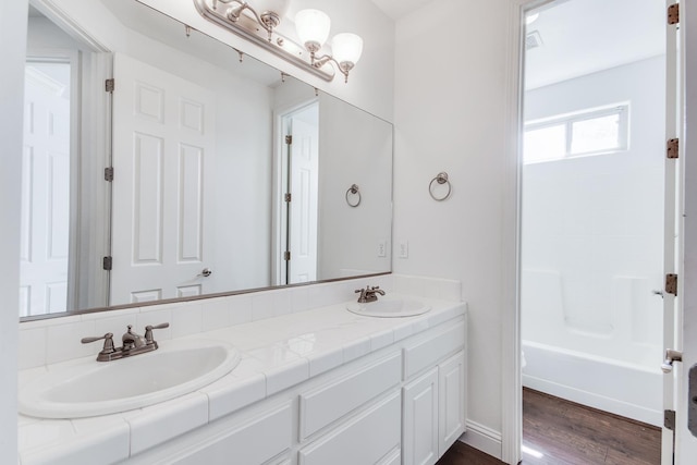 1090 Clara Ave, Fowler, CA 93625 - full bath featuring double vanity, wood finished floors, and shower / tub combination