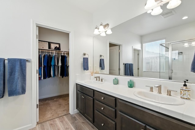 4146 Dennis Ave, Clovis, CA 93619 - full bathroom with wood finished floors, double vanity, a shower stall, and a walk in closet