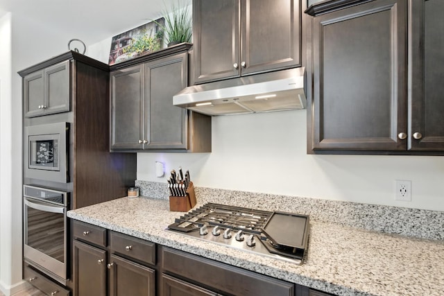 4146 Dennis Ave, Clovis, CA 93619 - kitchen featuring under cabinet range hood, stainless steel appliances, dark brown cabinets, and light stone counters