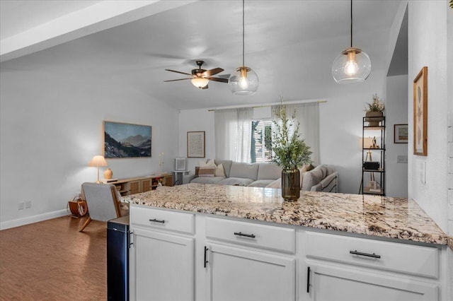 1448 Ashcroft Ave, Clovis, CA 93611 - kitchen with open floor plan, a ceiling fan, white cabinetry, dark wood finished floors, and light stone countertops