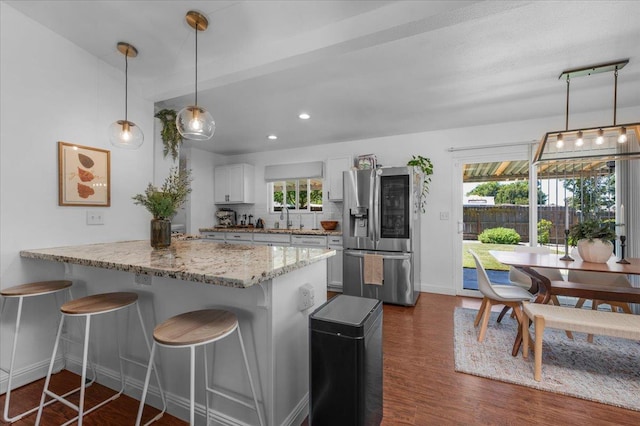 1448 Ashcroft Ave, Clovis, CA 93611 - kitchen featuring stainless steel refrigerator with ice dispenser, a breakfast bar, plenty of natural light, a peninsula, and recessed lighting