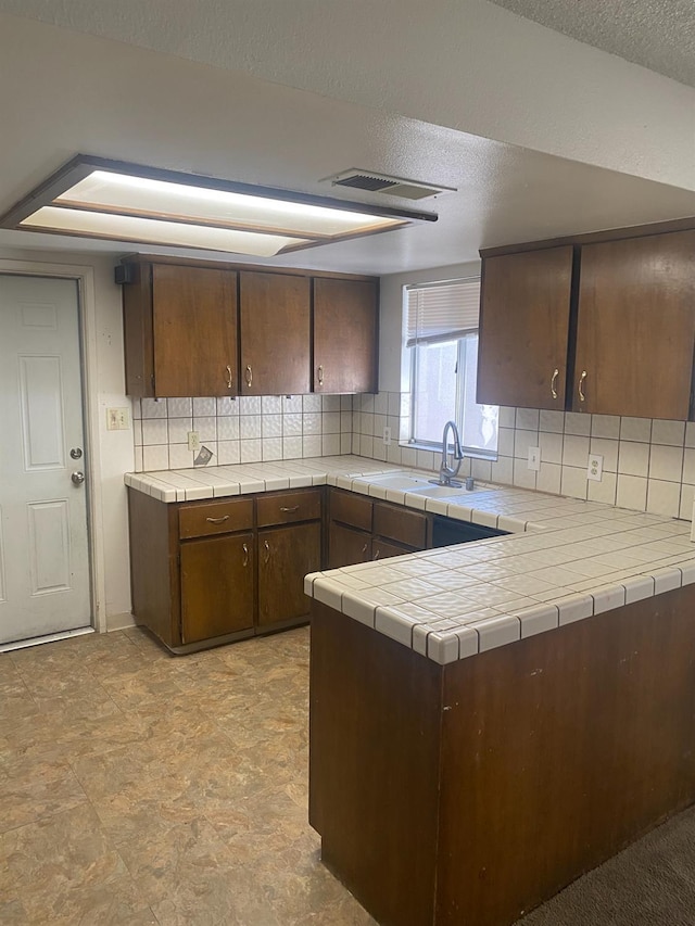 2673 N Marty Ave, Fresno, CA 93722 - kitchen with decorative backsplash, a textured ceiling, and tile countertops