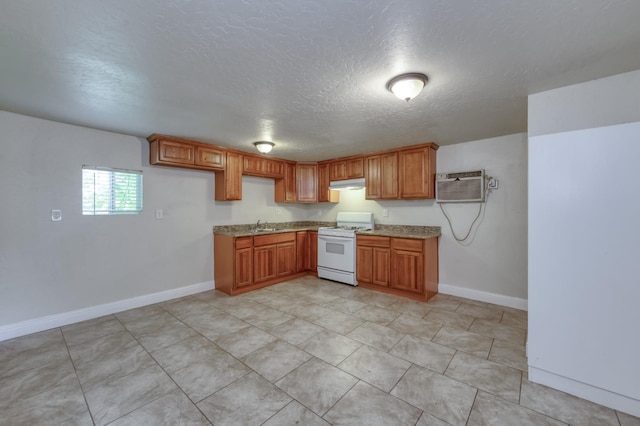 1437 N San Pablo Ave, Fresno, CA 93728 - kitchen with white range with gas stovetop, a wall mounted air conditioner, a textured ceiling, under cabinet range hood, and brown cabinets