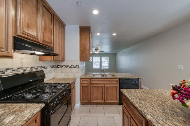 1437 N San Pablo Ave, Fresno, CA 93728 - kitchen with black appliances, under cabinet range hood, brown cabinetry, recessed lighting, and tasteful backsplash