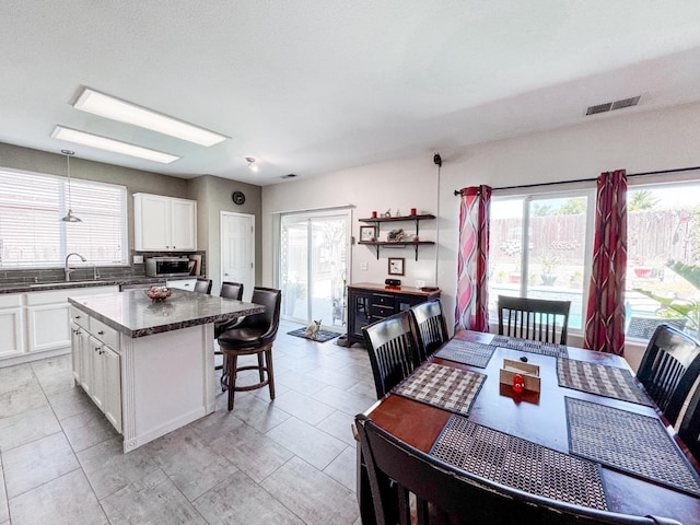 2457 Carson Ave, Clovis, CA 93611 - kitchen with dark countertops, a center island, white cabinetry, and a breakfast bar area