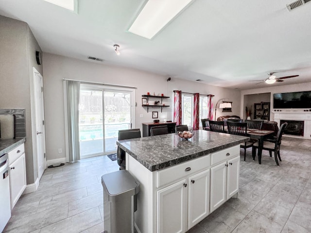 2457 Carson Ave, Clovis, CA 93611 - kitchen featuring dark countertops, ceiling fan, white cabinets, a kitchen island, and dishwasher