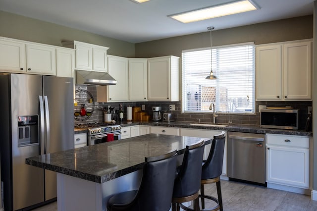 2457 Carson Ave, Clovis, CA 93611 - kitchen featuring stainless steel appliances, under cabinet range hood, tasteful backsplash, white cabinetry, and a breakfast bar area