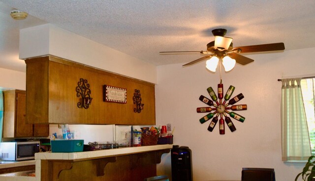 2415 Fordham Ave, Clovis, CA 93611 - bar area featuring stainless steel microwave, ceiling fan, and a textured ceiling