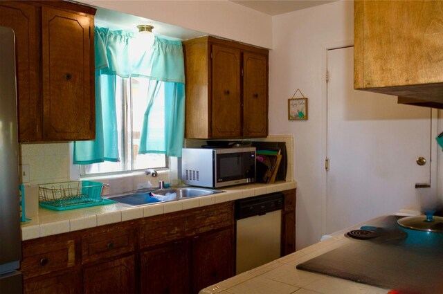 2415 Fordham Ave, Clovis, CA 93611 - kitchen featuring appliances with stainless steel finishes, tile countertops, and brown cabinets