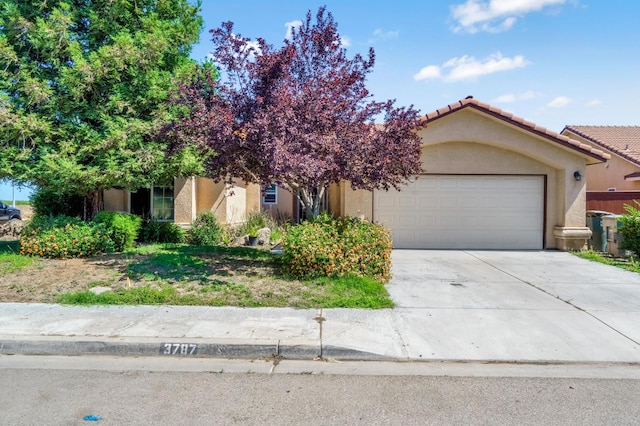 3787 Via Capitola, Madera, CA 93637 - view of front of property featuring stucco siding, an attached garage, concrete driveway, and a tiled roof