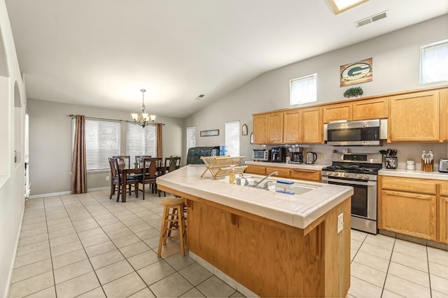 3787 Via Capitola, Madera, CA 93637 - kitchen featuring stainless steel appliances, light tile patterned floors, a chandelier, tile counters, and vaulted ceiling