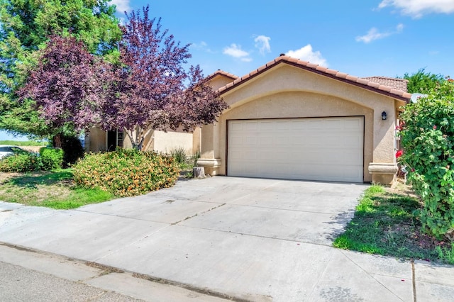 3787 Via Capitola, Madera, CA 93637 - view of front of house featuring stucco siding, a garage, driveway, and a tiled roof