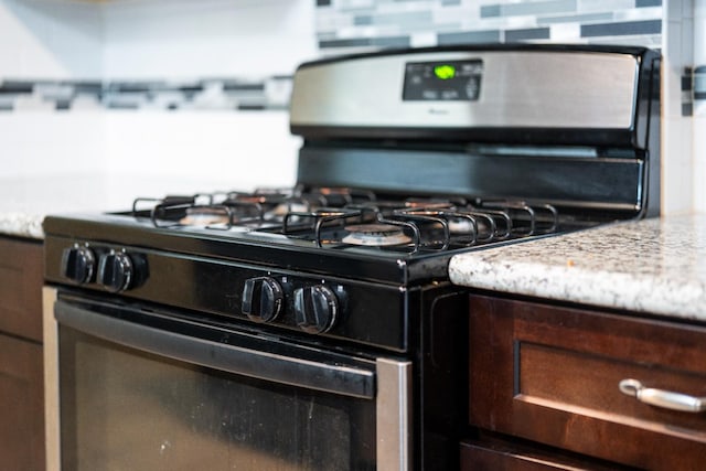 4115 E Montecito Ave, Fresno, CA 93702 - kitchen view of stainless steel range with gas stovetop and dark brown cabinetry