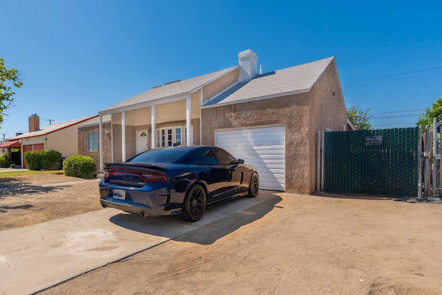 4115 E Montecito Ave, Fresno, CA 93702 - view of front facade featuring driveway, a garage, a chimney, and stucco siding