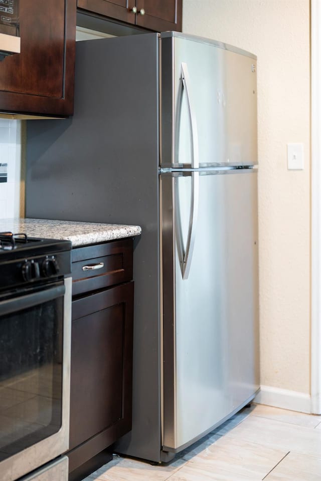 4115 E Montecito Ave, Fresno, CA 93702 - kitchen with appliances with stainless steel finishes, dark brown cabinets, and light wood-style floors