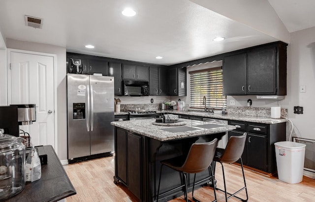 2816 Monocott, Madera, CA 93637 - kitchen featuring stainless steel appliances, dark cabinetry, light wood-style flooring, a kitchen island, and recessed lighting