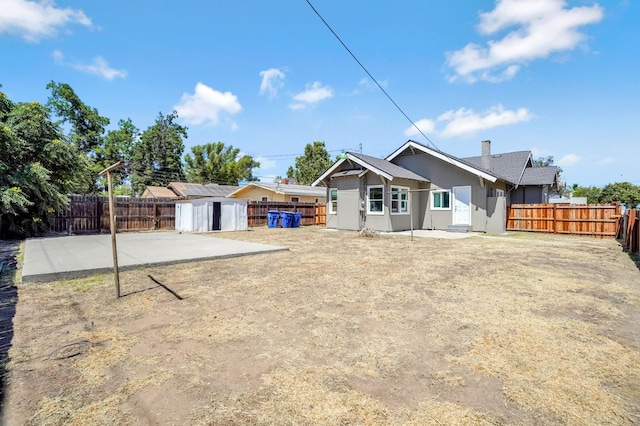 1303 N Calaveras St, Fresno, CA 93728 - back of property featuring a fenced backyard, a storage unit, and a patio
