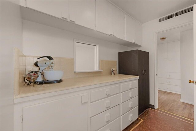 5481 E Geary St, Fresno, CA 93727 - kitchen with white cabinetry, tile counters, and tasteful backsplash