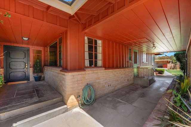 5481 E Geary St, Fresno, CA 93727 - view of exterior entry featuring covered porch, board and batten siding, and brick siding