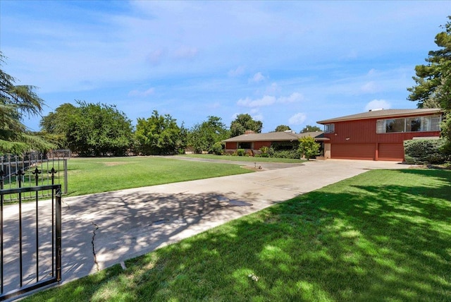 5481 E Geary St, Fresno, CA 93727 - view of green lawn with an attached garage and concrete driveway