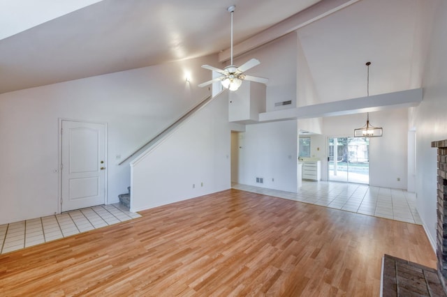 9340 N Jackson Ave, Fresno, CA 93720 - unfurnished living room featuring light wood-type flooring, stairway, a ceiling fan, high vaulted ceiling, and a fireplace