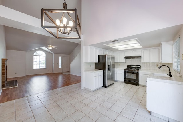 9340 N Jackson Ave, Fresno, CA 93720 - kitchen with black gas range, stainless steel fridge with ice dispenser, light tile patterned flooring, under cabinet range hood, and open floor plan