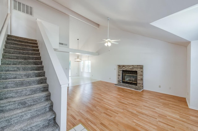 9340 N Jackson Ave, Fresno, CA 93720 - stairway with a ceiling fan, wood finished floors, a brick fireplace, and high vaulted ceiling