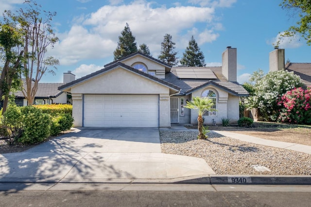 9340 N Jackson Ave, Fresno, CA 93720 - ranch-style home with stucco siding, concrete driveway, a garage, a tiled roof, and a chimney