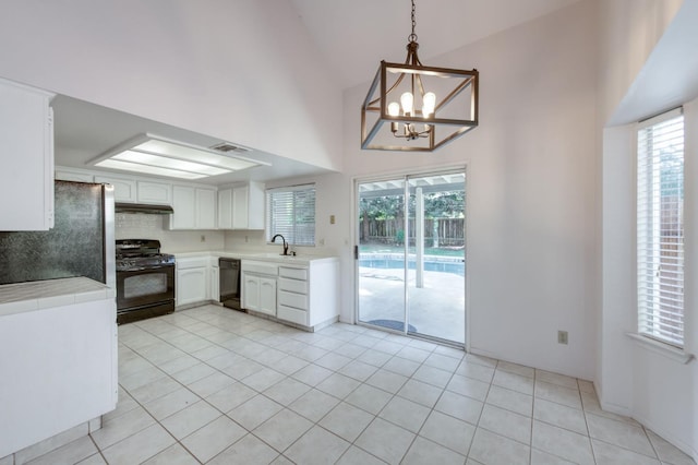 9340 N Jackson Ave, Fresno, CA 93720 - kitchen featuring black appliances, a towering ceiling, a chandelier, white cabinetry, and plenty of natural light