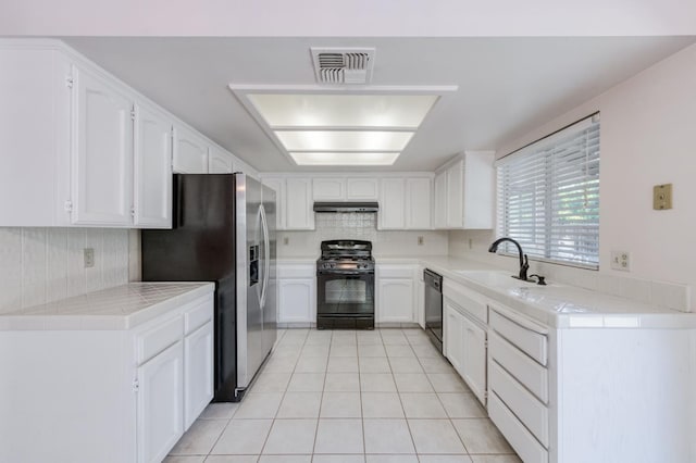 9340 N Jackson Ave, Fresno, CA 93720 - kitchen featuring black gas stove, stainless steel fridge with ice dispenser, dishwashing machine, light tile patterned floors, and white cabinetry