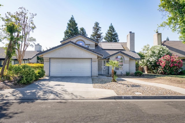 9340 N Jackson Ave, Fresno, CA 93720 - view of front facade featuring stucco siding, a garage, driveway, and a tiled roof