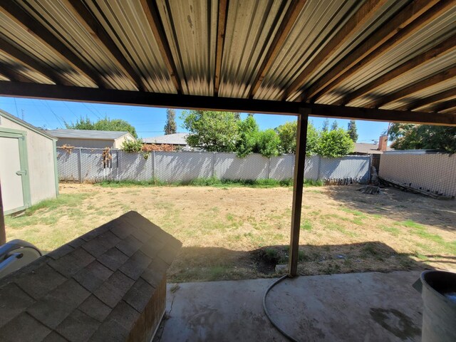 fenced backyard featuring a patio and a storage unit