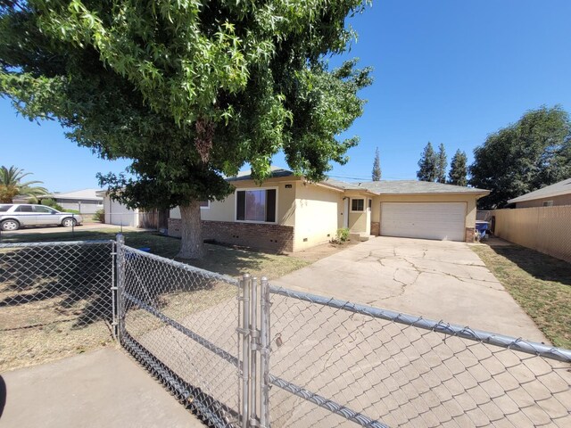 single story home featuring driveway, a garage, stucco siding, brick siding, and a gate