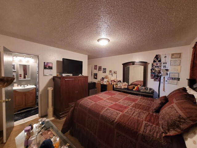 bedroom featuring a textured ceiling and connected bathroom