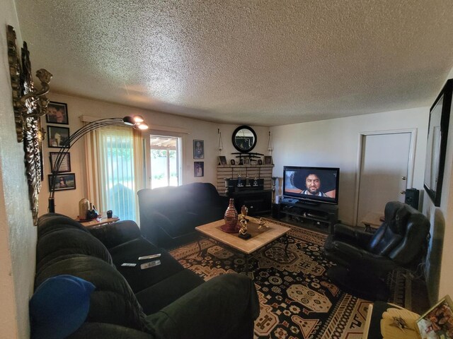 carpeted living room featuring a textured ceiling and a fireplace