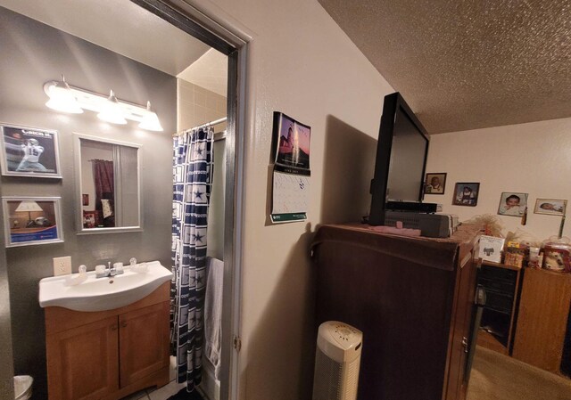 full bath with vanity, a textured ceiling, and a shower with shower curtain